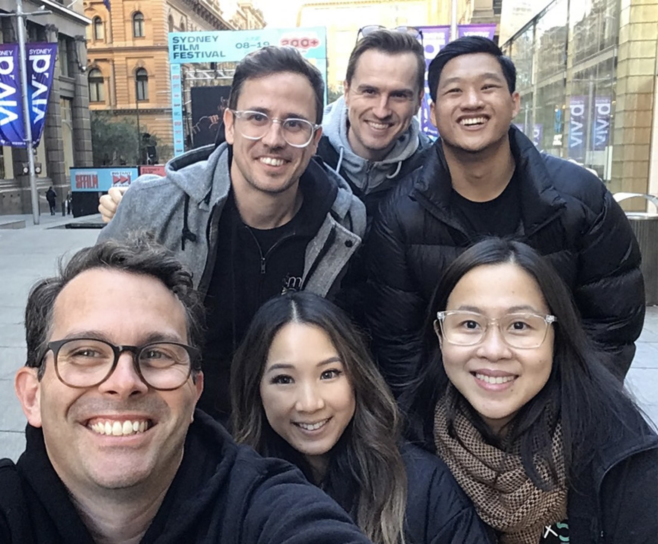 Small group of mx51 colleagues taking a selfie and smiling at the camera.